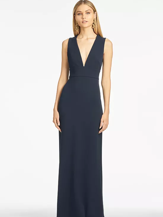 A model shows off a sleeveless navy blue dress with a plunging V-neck.