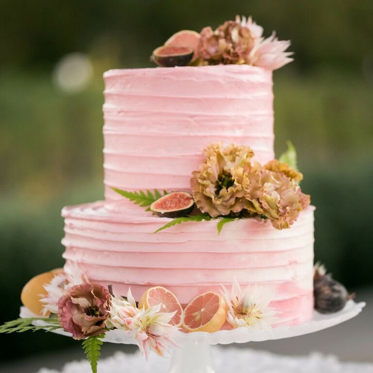 Two-tier pink cake with fresh fruit decorations