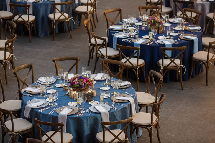 At the reception, round dining tables covered in a variety of linens brought color to the atrium space. A gray napkin was draped over the top of the plate at each setting, where guests sat in farmhouse chairs.