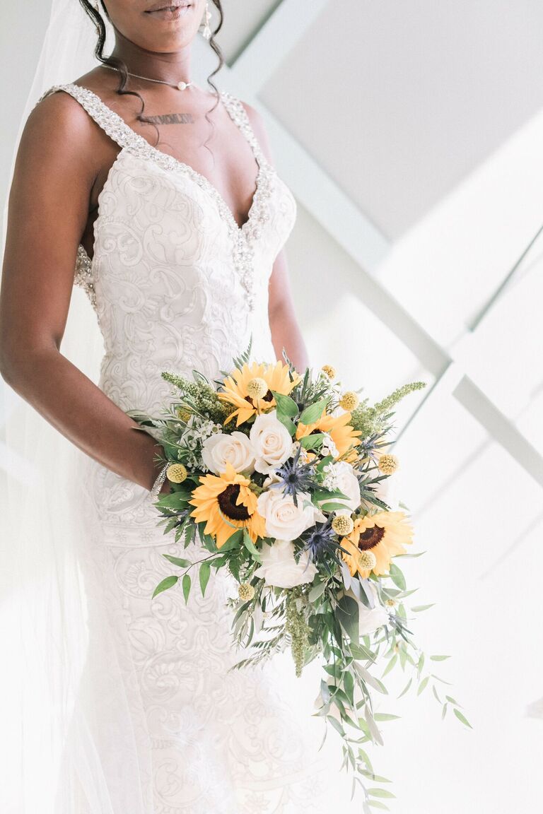 Bride holding bouquet with sunflowers and white roses