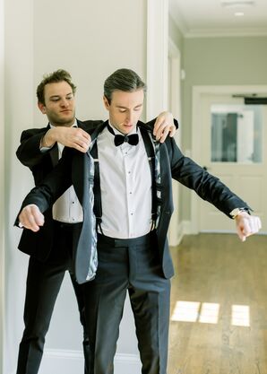 Groom is Helped into His Classic Black Tuxedo Jacket With Foliage-Print Liner
