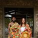 A groom and bride in traditional, colorful Ghanaian Kente featuring yellow, red, green and purple, as well as a headpiece and necklaces, for a multicultural wedding featuring customs from Ghana, India, and Europe.