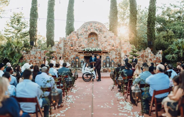 Outdoor wedding ceremony with stone backdrop