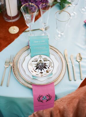 Place Setting With Teal-and-Pink Napkin and Gold Flatware