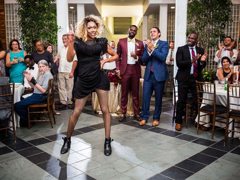 Grooms watching drag performance at wedding reception