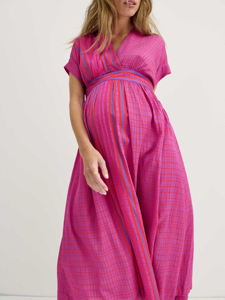 Model wears a plaid pink and red maxi dress. 