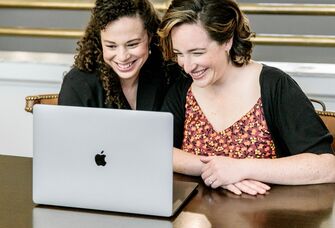 Engaged couple starting their wedding registry on laptop at home