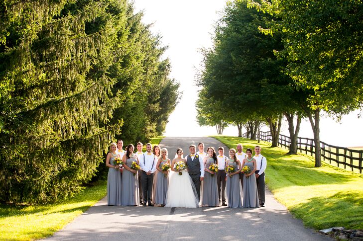 Haley and Jeremiah stood in the middle of their wedding party, dressed in different shades of gray. The groomsmen sported charcoal gray suspenders attached to their matching pants, while the bridesmaids wore heather gray floor-length dresses.