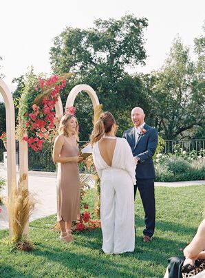 Bride and Groom Exchanging Vows Beside a Triple Wedding Arch