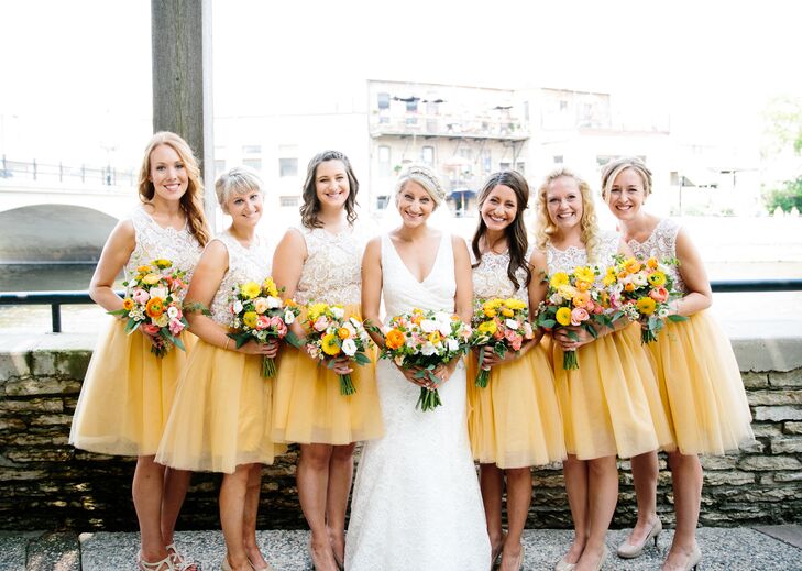 The bridesmaids wore knee-length yellow and white dresses for the retro homespun barn wedding. Katie loved the flowing tulle skirts and chic lace bodices. Each of the women chose their own nude shoes and their hairstyle for the day for a little personalization on the otherwise uniform look.