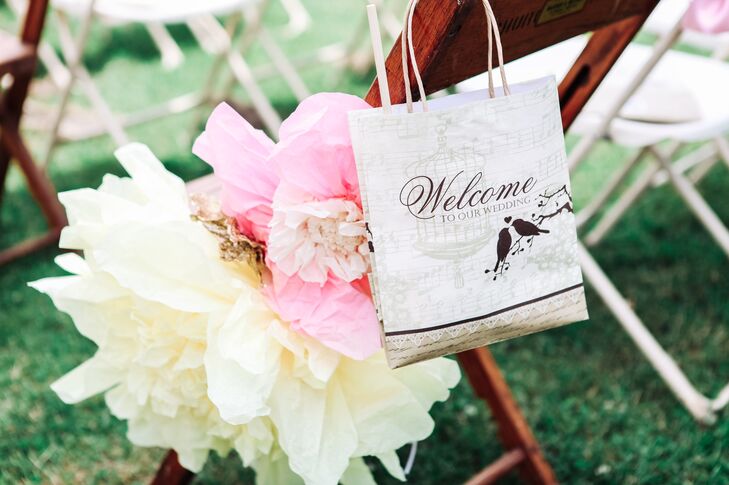 The chairs on the ceremony aisle were decorated with ivory and blush paper flowers made by Etsy designer Especially for You by Y.W. Each chair also had a welcome bag for guests.