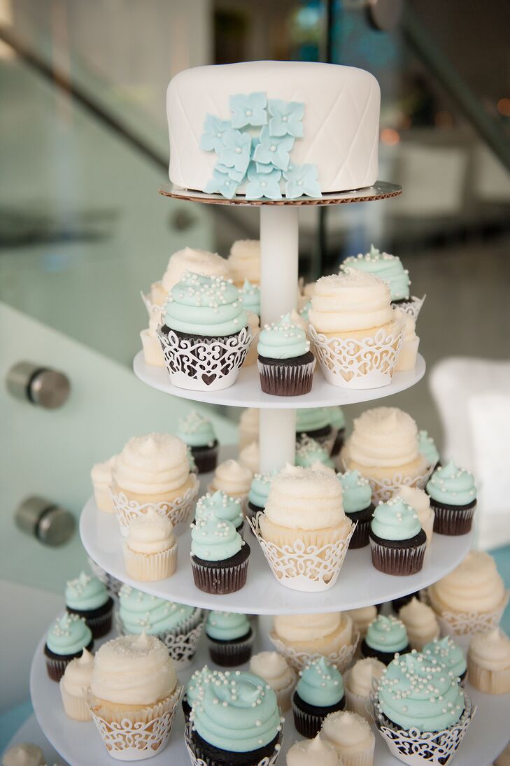 Instead of a tiered wedding cake, Brianna and Ryan had a cupcake tower with large and mini cupcakes. The cupcakes were vanilla with white frosting and sugar dust or chocolate with light aqua frosting and white pearl accents. Their single-tier cake on top had quilted ivory fondant with a few fondant aqua hydrangeas to tie in the palette.