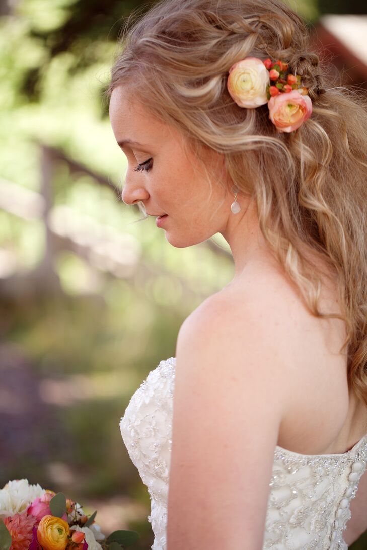 Brynn wore peach-colored ranunculus in her wavy, half up hairstyle.