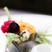 An assortment of dahlias, ranunculus and hypericum in geometric vases topped the round cocktail tables.