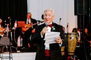 Man in  Classic Tuxedo With Red Details Giving a Toast at Wedding Reception