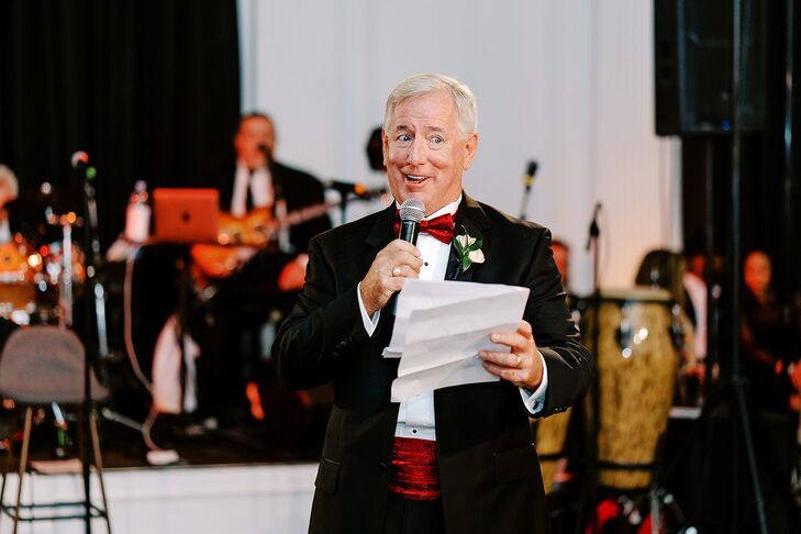 Man in  Classic Tuxedo With Red Details Giving a Toast at Wedding Reception