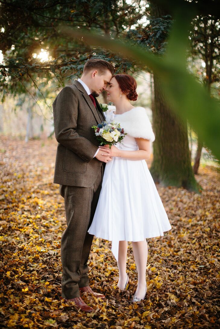 Louise wore a non-traditional, knee-length wedding dress in the style of the 1950s. She paired her dress with a fur stole for the fall weather, and she styled her hair in a chignon for the day.