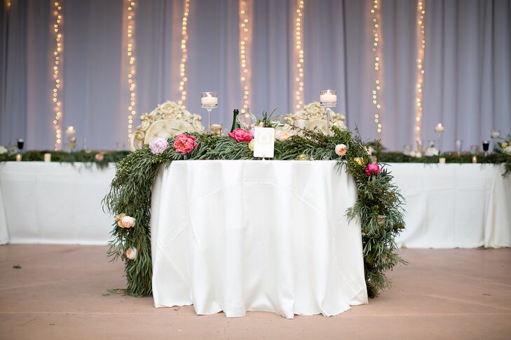 For the reception, the space was outfitted with vertical strands of twinkle lights and garland runners on tables. The sweetheart table had a floral and garland runner.