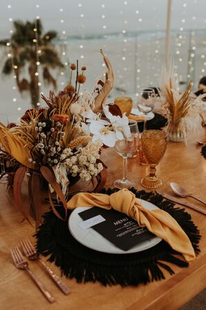 Boho Place Setting With Black Rattan Charger and Orange Napkin