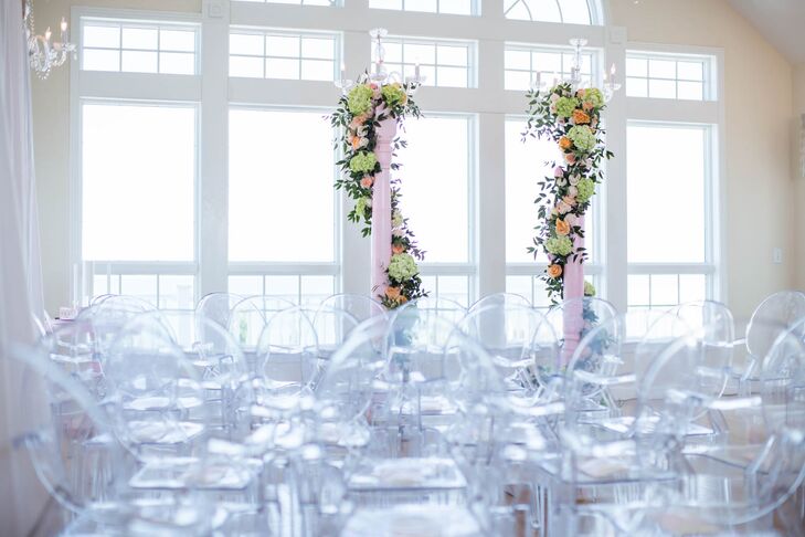Ryan and Brian exchanged vows in the penthouse of the beachfront estate. They loved the oversize windows and amazing vistas of the ocean and dunes. Wedding planner Glam and Lace and florist Renee Landry Events worked together to set up two blush pillars, which they wrapped with peach and green flowers.