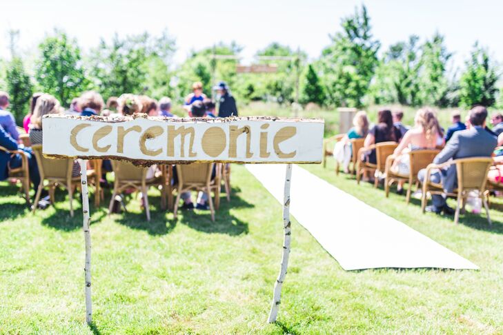Guests were greeted by a DIY ceremony sign posted on birch wood posts.