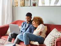 Couple creating bridal shower registry on laptop at home