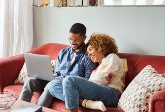 Couple creating bridal shower registry on laptop at home