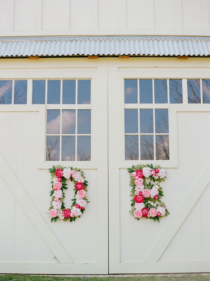 "A large focus of our wedding was florals, so I picked flowers with many shades of pink," Deborah says. These monogram letters were crafted by Houston's Flower Vibes and hung on the doors of the barn at Chandelier Grove in Tomball, Texas, where the reception was held.