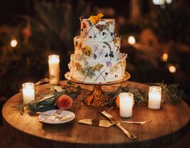 three tier buttercream wedding cake decorated with dried and pressed flowers in different colors
