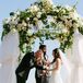 Alyssa and Alex got married under a chuppah adorned with ivory blooms and greenery at the top, and thick white sheets covering the sides.