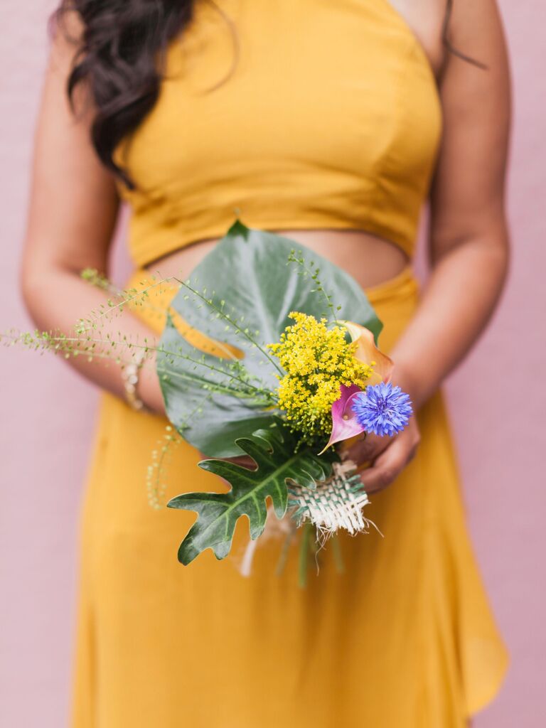 A bridesmaid holds a vibrant wildflower bouquet.