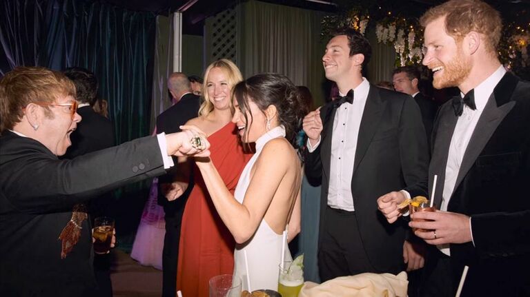 Meghan Markle and Prince Harry talking to Elton John at their wedding reception