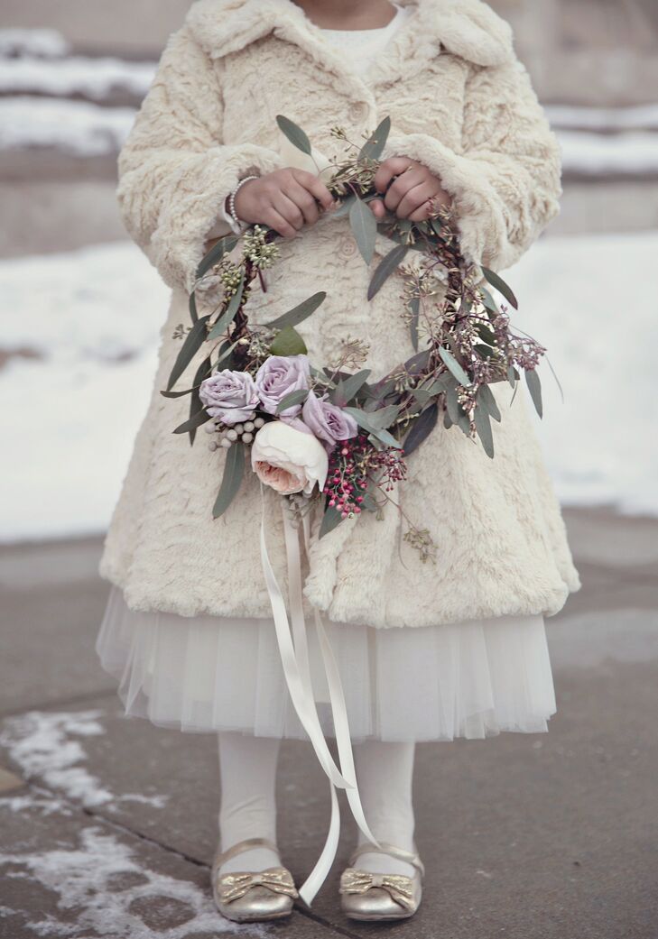 The three flower girls wore matching ivory fur coats and carried wreaths made of fresh eucalyptus, garden roses and silver spray roses.