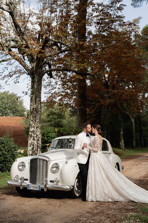 Bride and Groom Pose With Vintage White Getaway Car