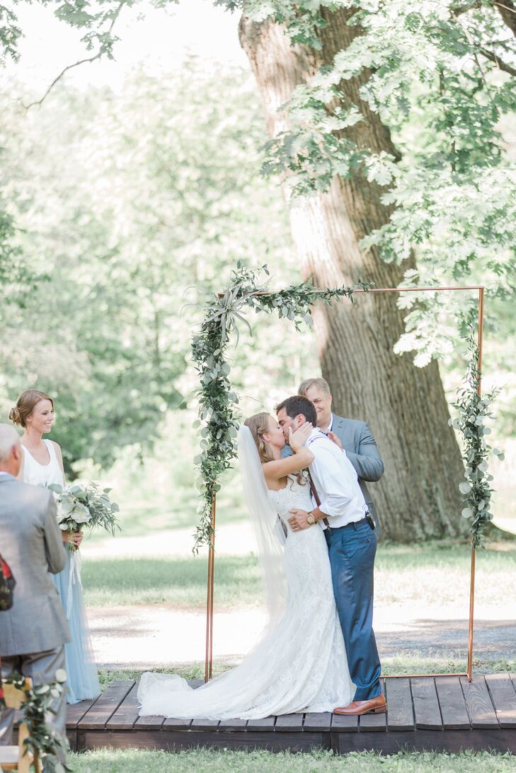 First Kiss in Front of Copper Arch Dressed with Eucalyptus and Air Plants