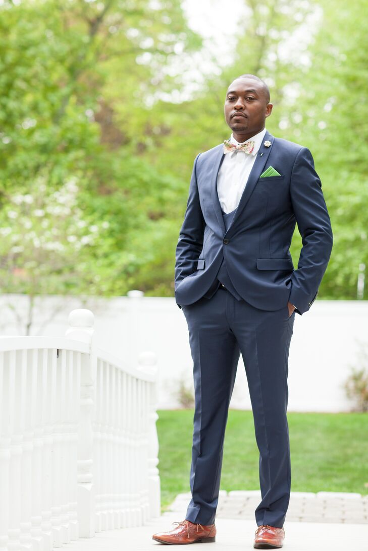 Luke donned a striking navy Noose and Monkey suit for the wedding. He opted for a modern shawl collar style and added a waistcoat for a little extra polish. Instead of the traditional tie and boutonniere, he wore a floral bow tie and a pearl and rhinestone brooch, which complemented those in Diseanna’s bouquet. And for a chic finish, Luke added a green pocket square.