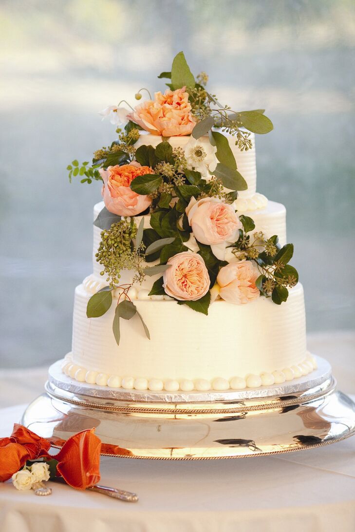 The three-tier vanilla cake with fresh strawberry filling was iced in buttercream and topped with Juliet roses.
