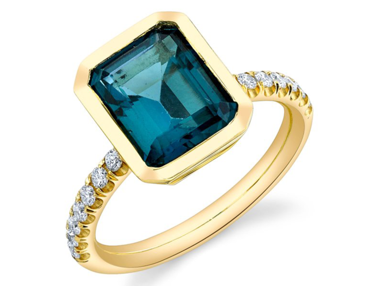 Emerald cut topaz center stone with gold setting and pave diamonds on gold band