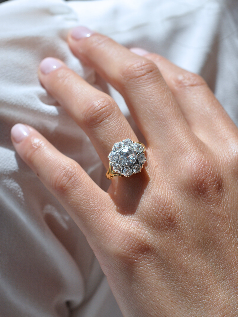 Round center diamond with floral diamond halo on gold band