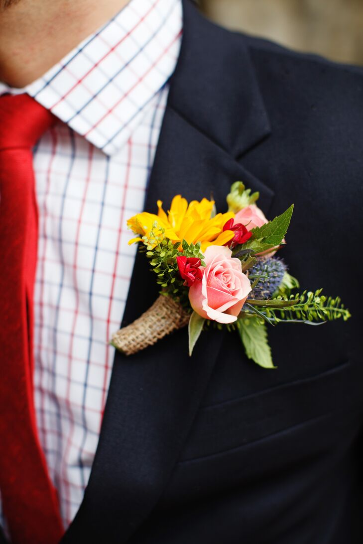 Evan's boutonniere felt like it had been swept up from a meadow on his way to the wedding. It had pink roses, a yellow daisy, a blue thistle, and pops of red flowers and greenery.