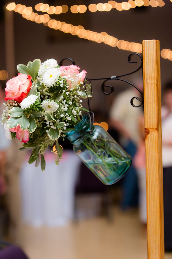 “Roses, coffee bean pods, peonies, baby's breath, and green filler were held in blue glass mason jars that came from Micaela's great grandmother,” says the couple.