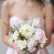 Each bridesmaid paired her classic look with a soft, romantic bouquet from Victoria's Garden. Blush peonies, white roses, white dahlias, pink delphiniums, dusty miller and greenery were gathered in a bold, glitter-covered gold ribbon for the arrangement.