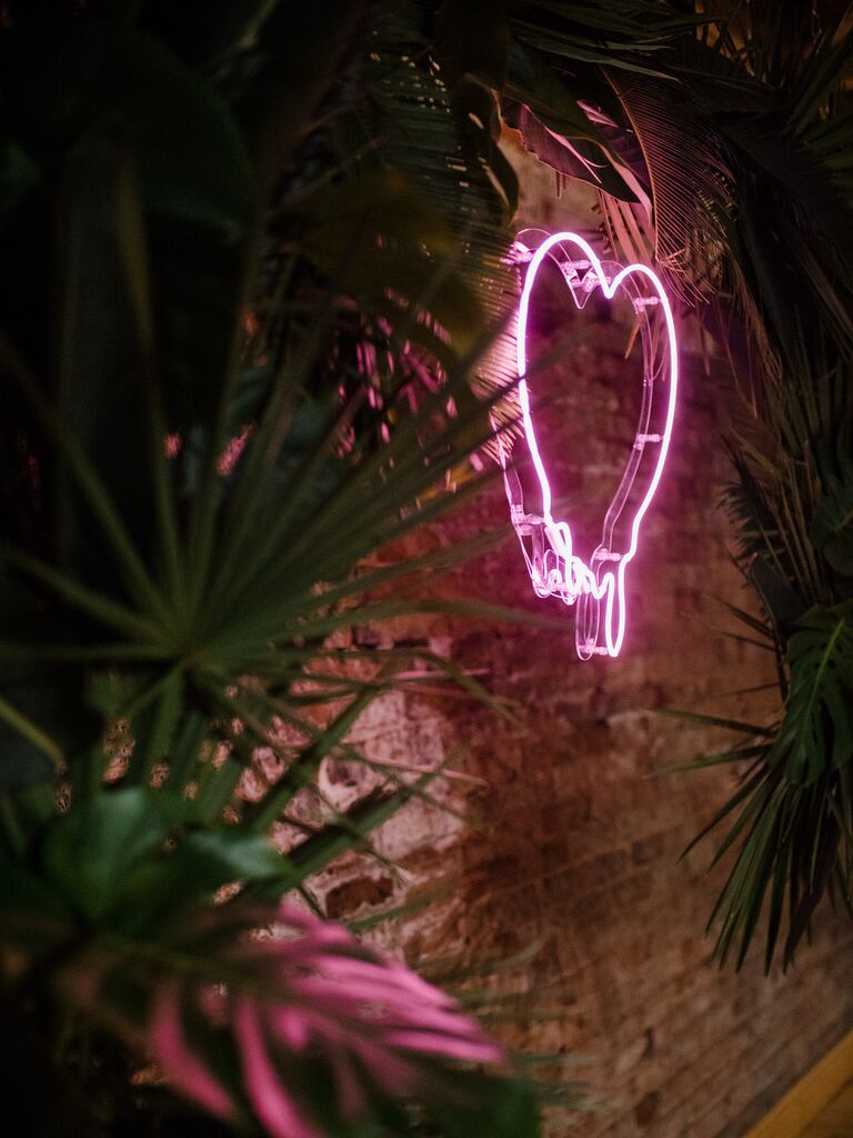 pink heart shaped neon sign on brick wall