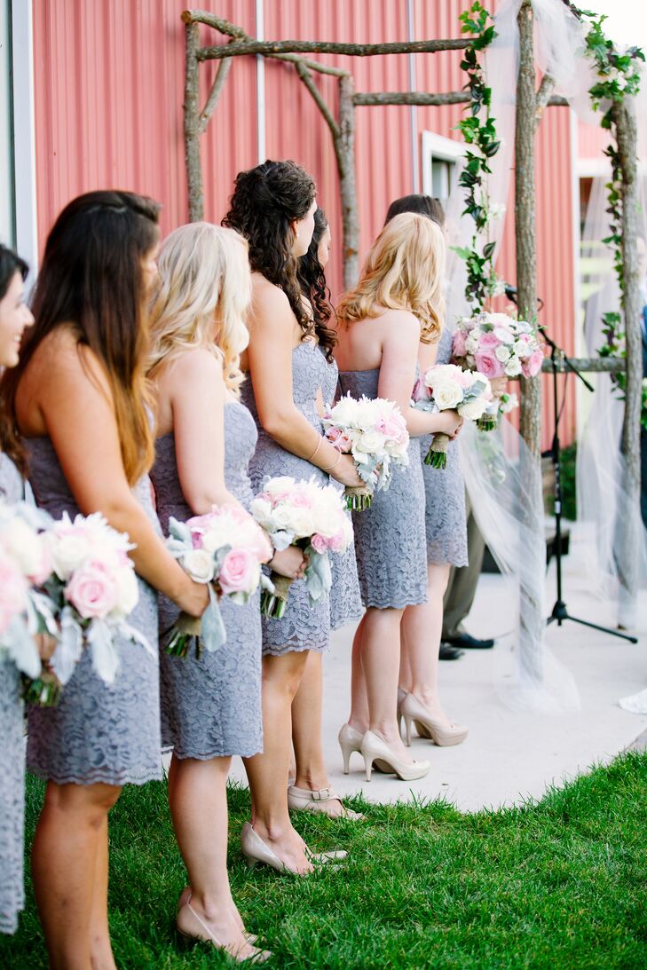 "I love lace bridesmaid dresses," Bethany says. They found the perfect style at David's Bridal. On the day-of each bridesmaid carried a pretty bouquet made up of pink and white roses and dusty miller. They wore their hair half-up or down and accessorized with nude heels to complete the look.
