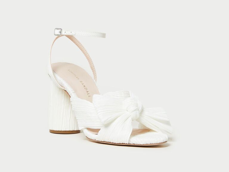 White high heel with an open toe and a large bow. 