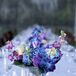 A mix of blue and purple flowers in low mercury glass vases topped the long reception tables.
