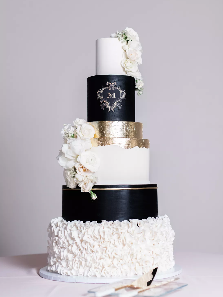 Sophisticated six-tier wedding cake in white, black, and gold