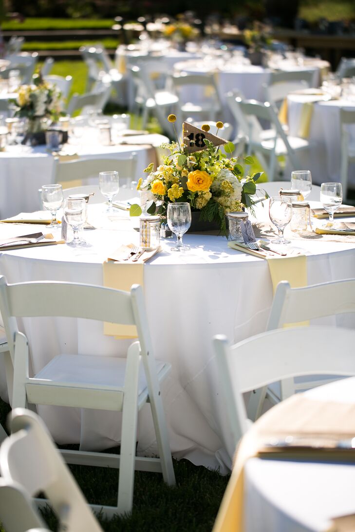 The reception took place outside at Amador Cellars in Plymouth, California, where yellow and green flower arrangements decorated round white dining tables. Burlap flags with numbers at each dining table helped guests find their seats.