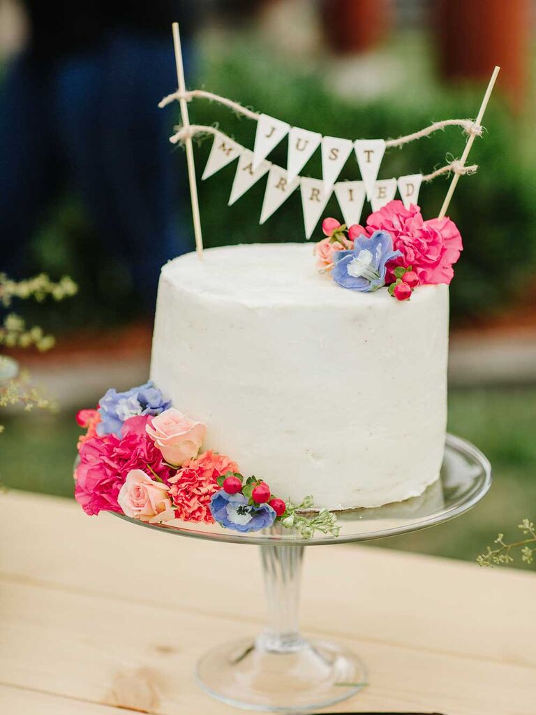 Small wedding cake with colorful flowers and burlap flag topper