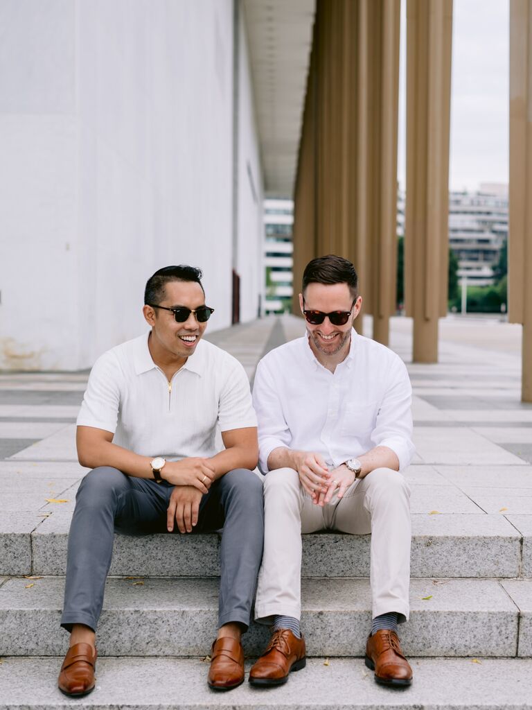 Two men wearing sunglasses smile for the camera in their engagement photo